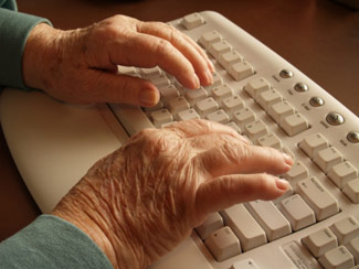 Seniors hands typing at keyboard